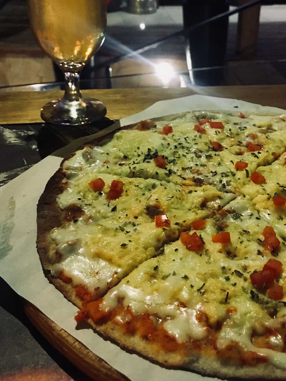 pizza de seis fatias e copo de chope em ilhabela