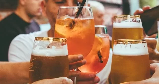pessoas brindam em bar